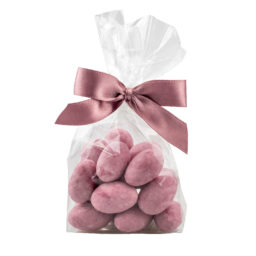 Migdał w białej czekoladzie barwiony na różowo w foliowym opakowaniu z kokardą